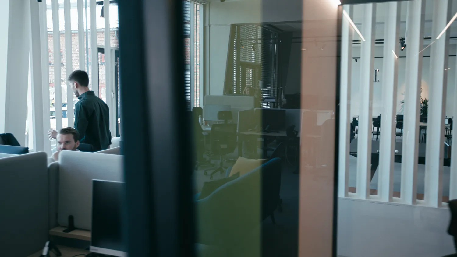 The Oslo office seen through its glass partitions, two colleagues talking at the far end