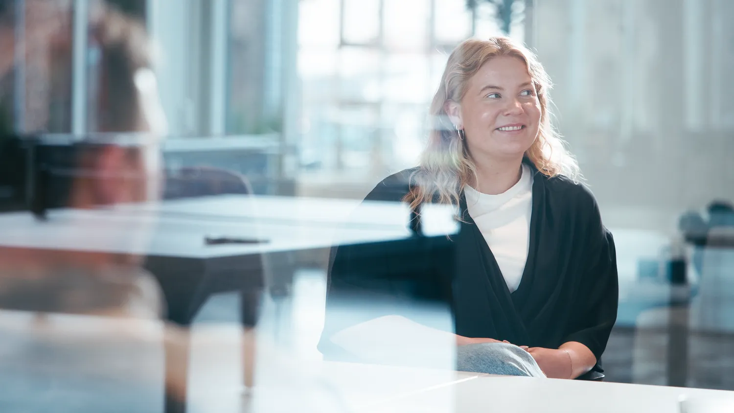 A colleague at a meeting table, looking out into the room